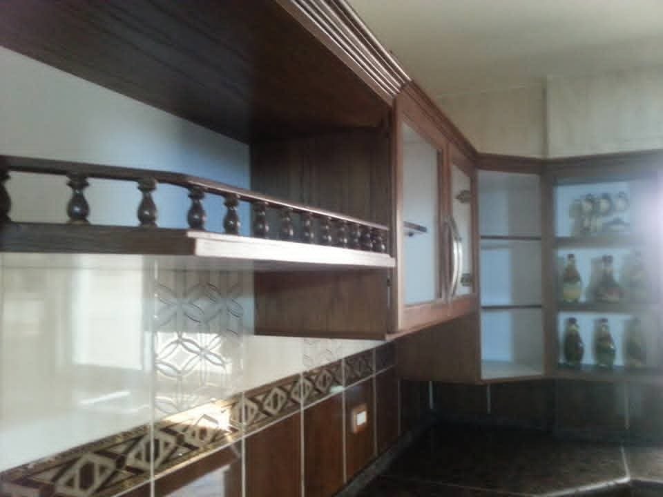 Open display shelf beside glass-front upper cabinets